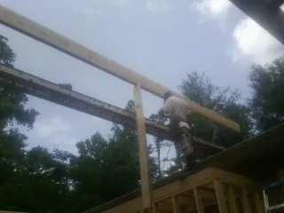 Carpenter setting a ridge beam over a new addition frame — Ice Dam Removal by Roofing Brothers in Wartrace