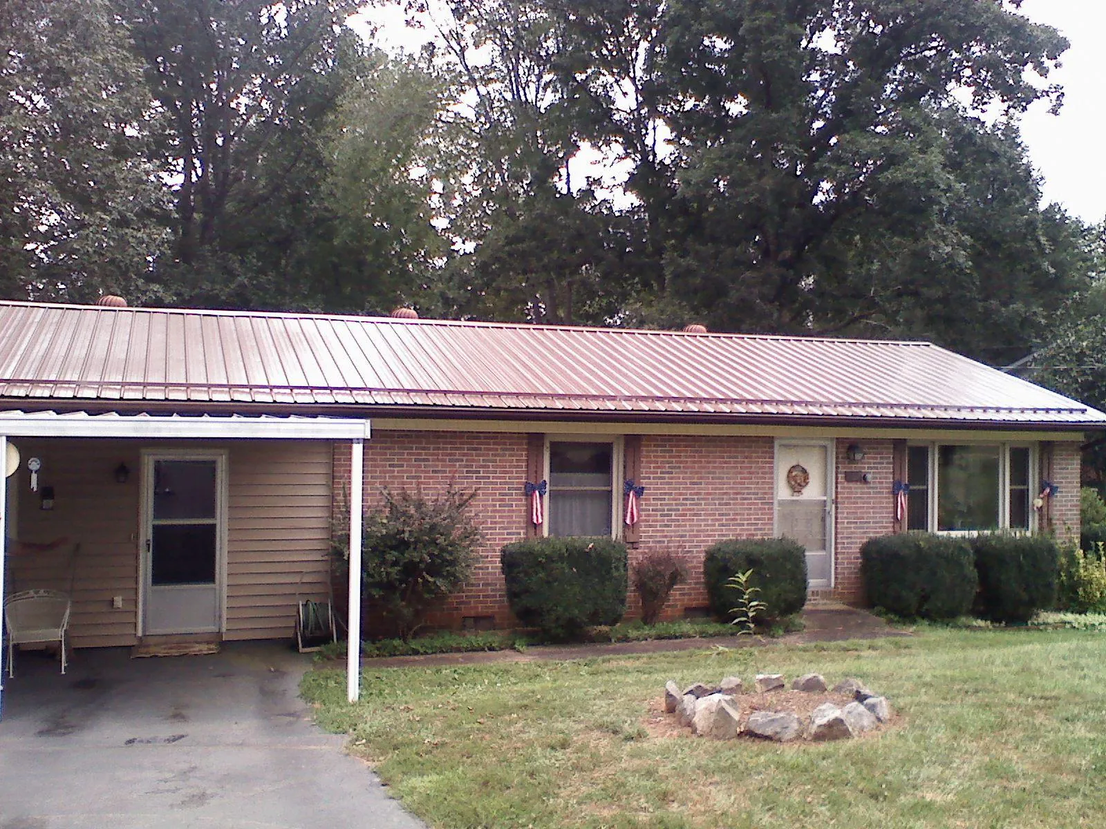 Bronze metal roof and carport on a brick ranch home — Roof Repair work by our crew in Wartrace